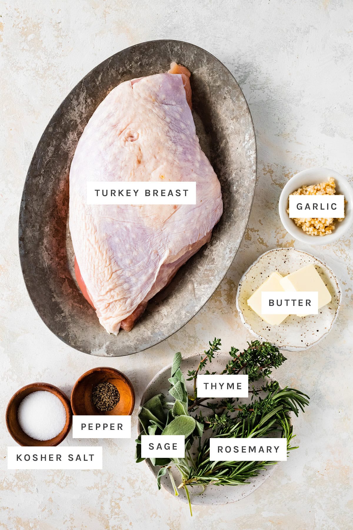 Ingredients measured out to make Air Fryer Turkey Breast: turkey breast, garlic, butter, thyme, sage, rosemary, kosher salt and pepper.