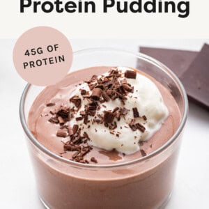 Chocolate Protein Pudding in a glass topped with whipped cream and shaved chocolate.
