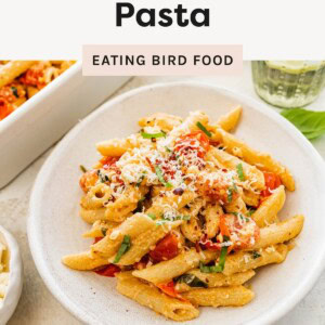 Bowl of baked feta pasta with cherry tomatoes, basil, and parmesan, labeled as an easy weeknight dinner.