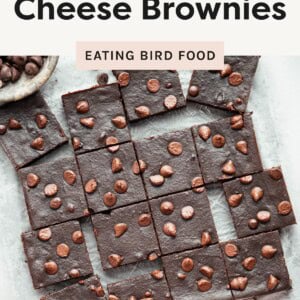 Sliced fudgy brownies topped with chocolate chips, arranged in a grid on parchment paper.