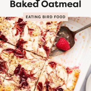 A pan of raspberry cottage cheese baked oatmeal cut into squares with a swirled raspberry pattern with a spoon in the corner.