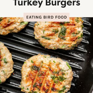 Spinach and feta turkey burgers grilling on a pan.