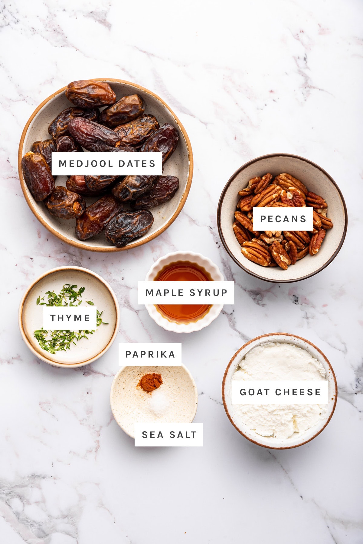 Ingredients measured out to make Stuffed Dates: medjool dates, pecans, maple syrup, thyme, paprika, sea salt and goat cheese.