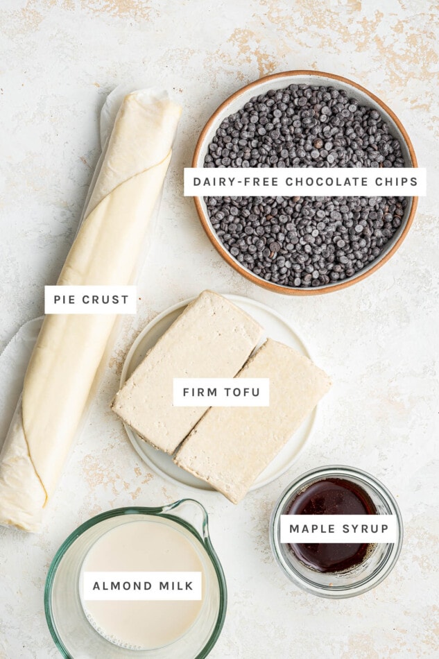 Ingredients measured out to make Vegan Chocolate Pie: pie crust, dairy-free chocolate chips, firm tofu, almond milk and maple syrup.