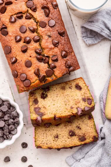 Almond flour banana bread with chocolate chips cut in two slices on a cooling rack.