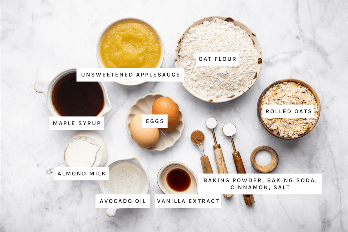 Applesauce Muffins ingredients: Unsweetened applesauce, oat flour, rolled oats, maple syrup, eggs, almond milk, avocado oil, vanilla extract, baking powder, baking soda, cinnamon, salt.