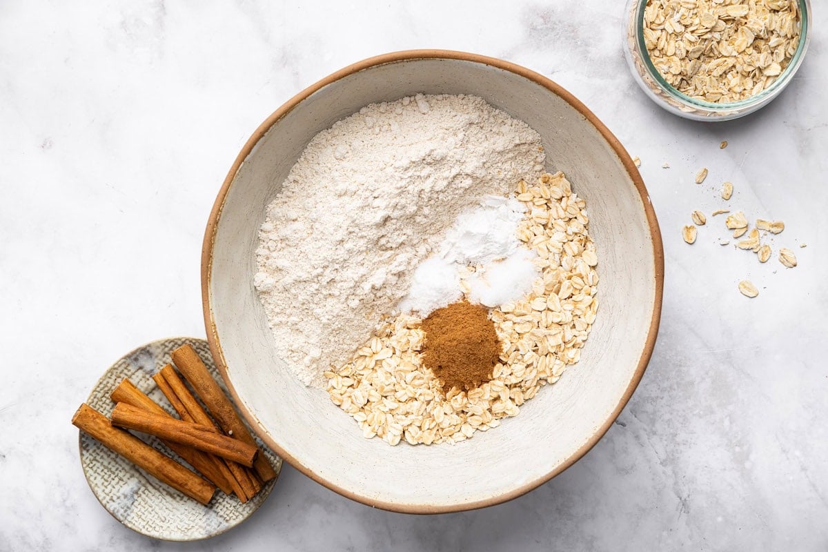 Dry ingredients for applesauce muffins: oat flour, rolled oats, cinnamon, baking powder, and baking soda.