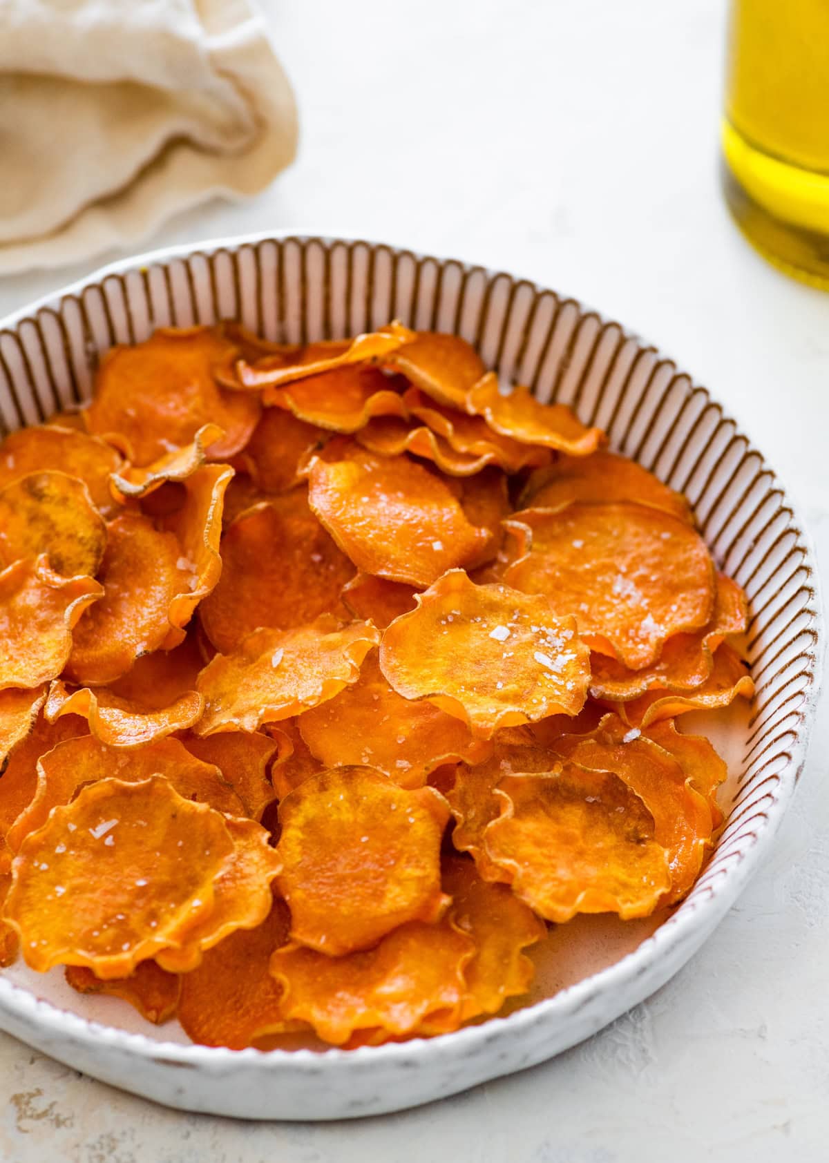 Close-up view of crispy sweet potato chips in a bowl.