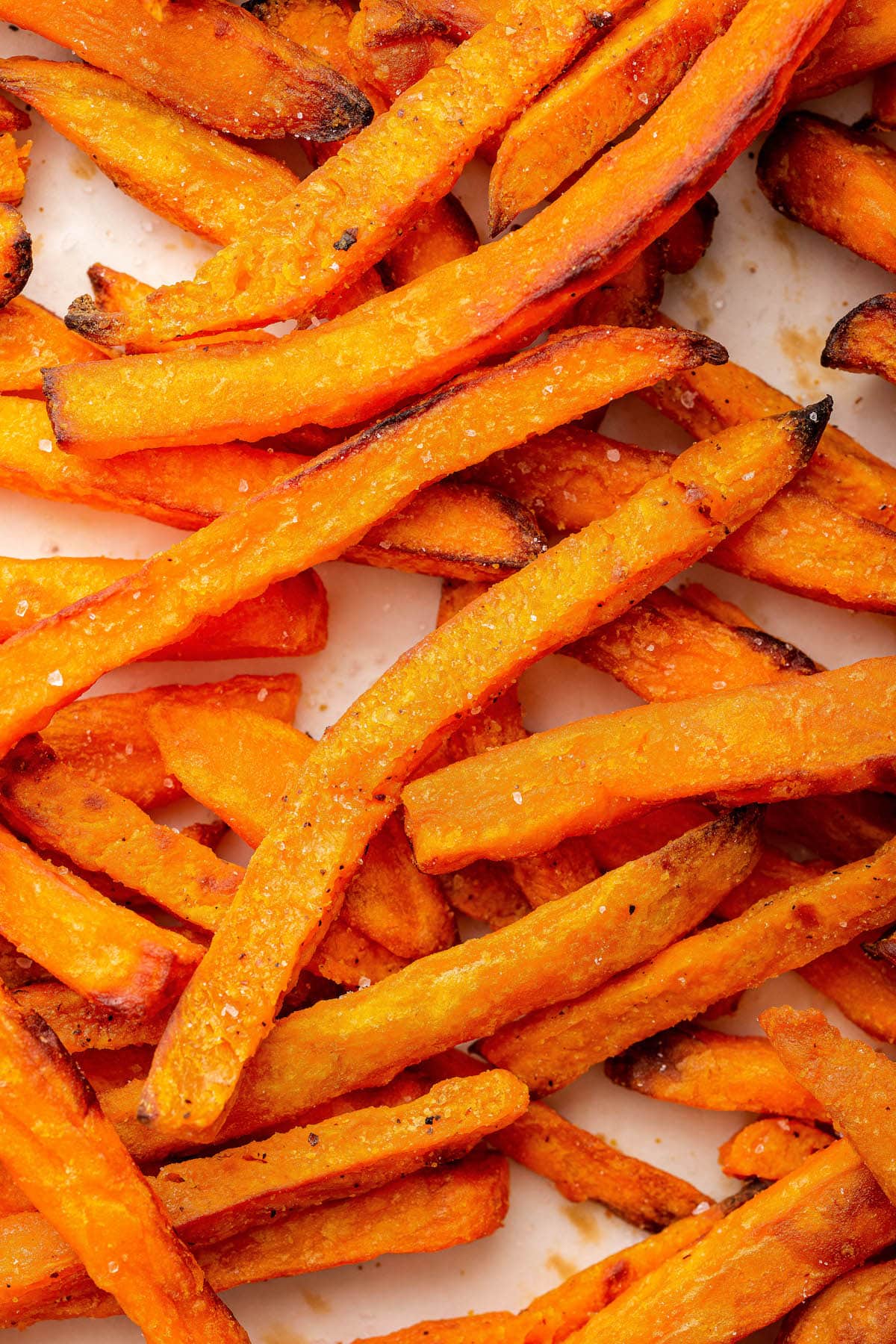 Baked sweet potato fries sprinkled with salt and lightly charred edges.