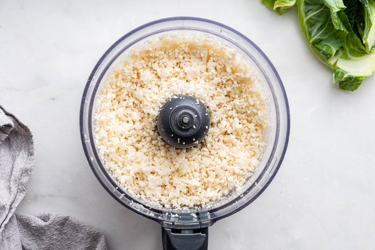 Cauliflower in a food processor being blended to make cauliflower rice.