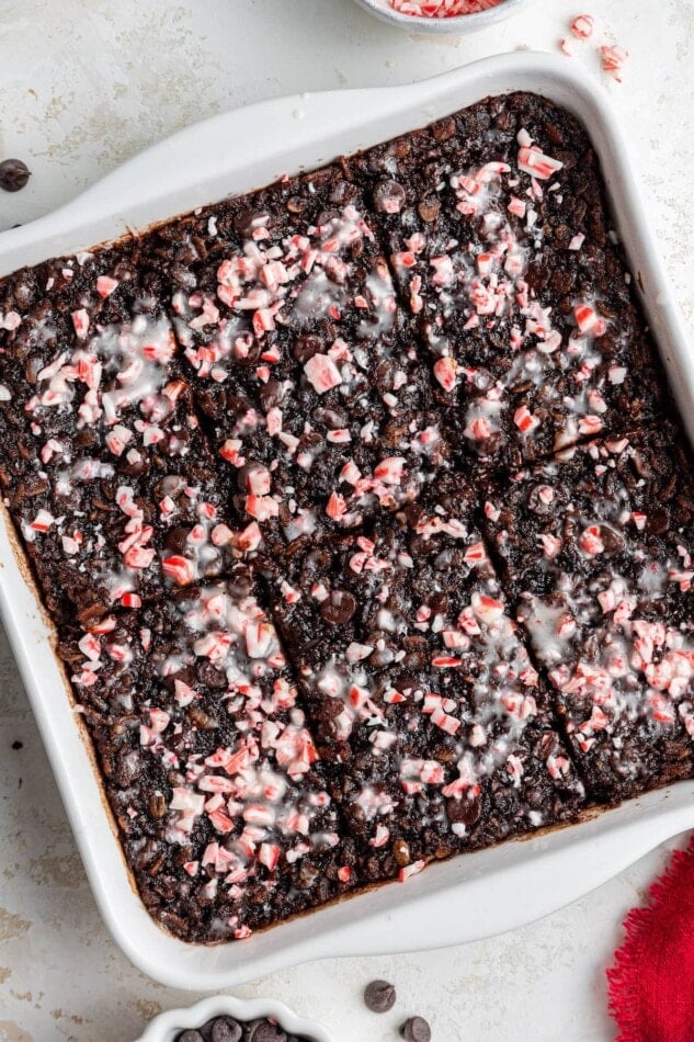 Chocolate peppermint baked oatmeal sliced into 6 equally sized pieces in a baking dish.