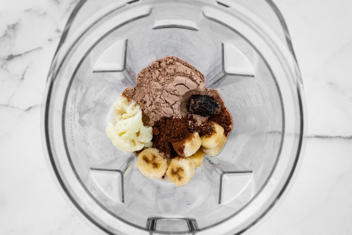 Almond milk, frozen banana, cauliflower florets, chocolate protein powder, cocoa powder, medjool date, and peppermint extract in a high powered blender.