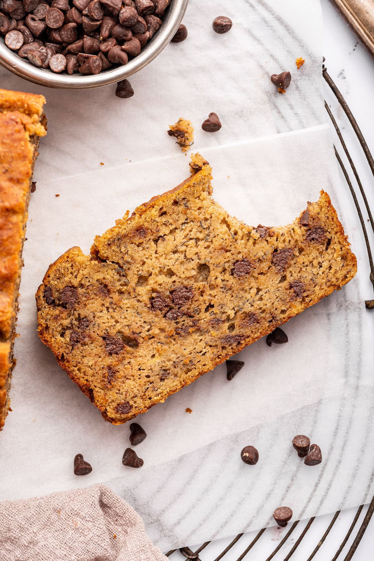 A slice of chocolate chip coconut flour banana bread with a bite taken from it.