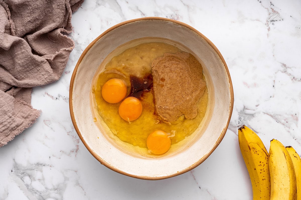 A large mixing bowl of wet ingredients used to make coconut flour banana bread.