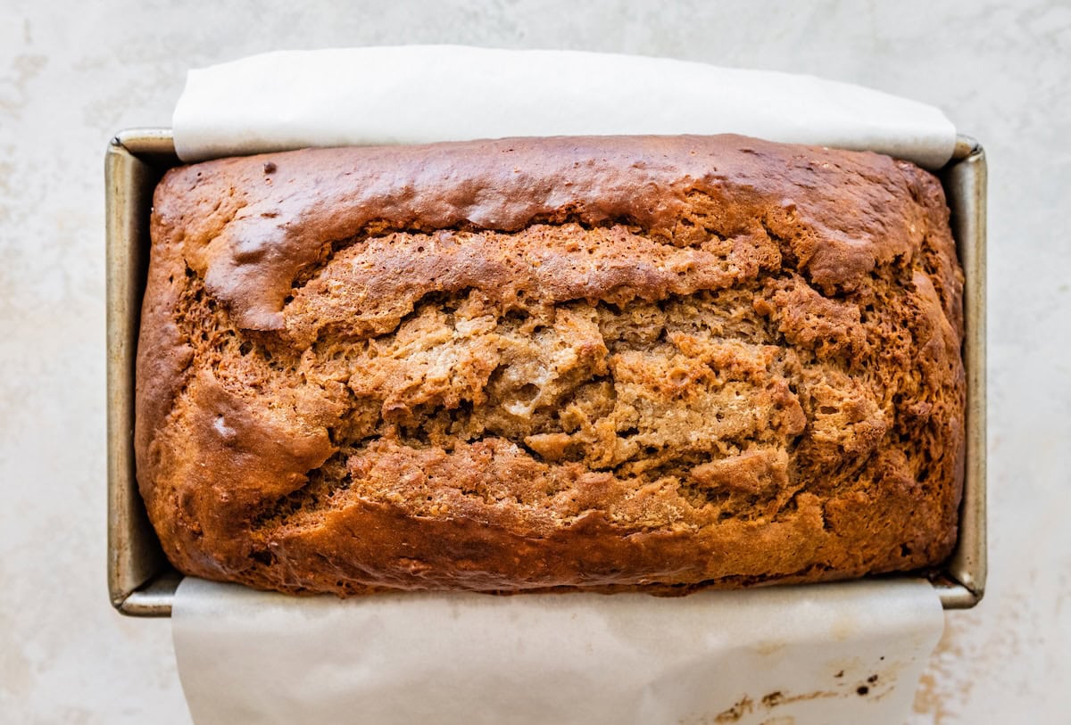 Whole loaf of cottage cheese banana bread in a loaf pan with golden crust.