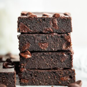 Stack of four cottage cheese brownies showing moist texture.
