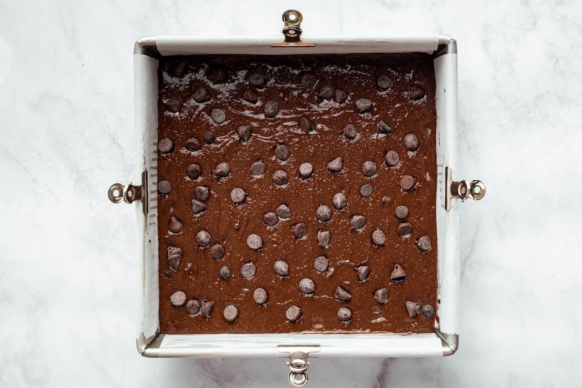 Pan of cottage cheese brownie batter topped with chocolate chips before baking.