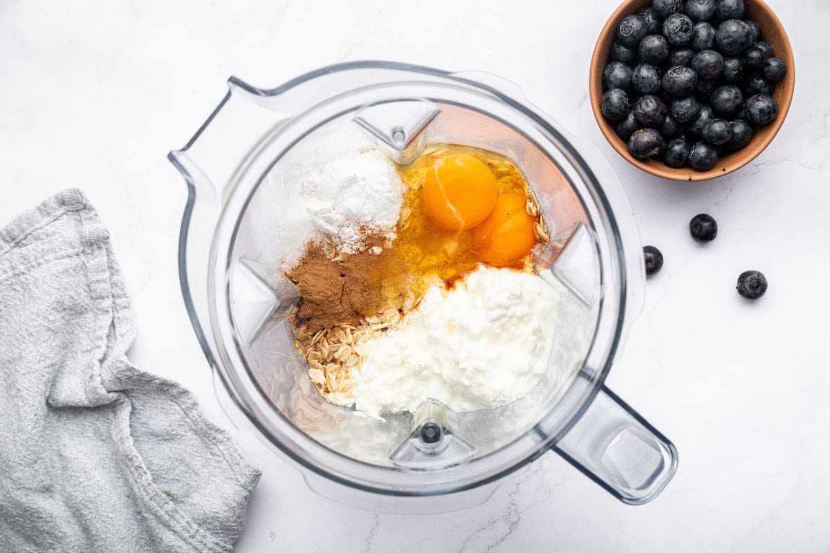 All the ingredients for the cottage cheese muffins in the base of a Vitamix blender before being blended.