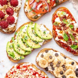 Assorted cottage cheese toast ideas topped with avocado, smoked salmon, pizza marinara, raspberries, banana with chocolate chips, and berry jam.