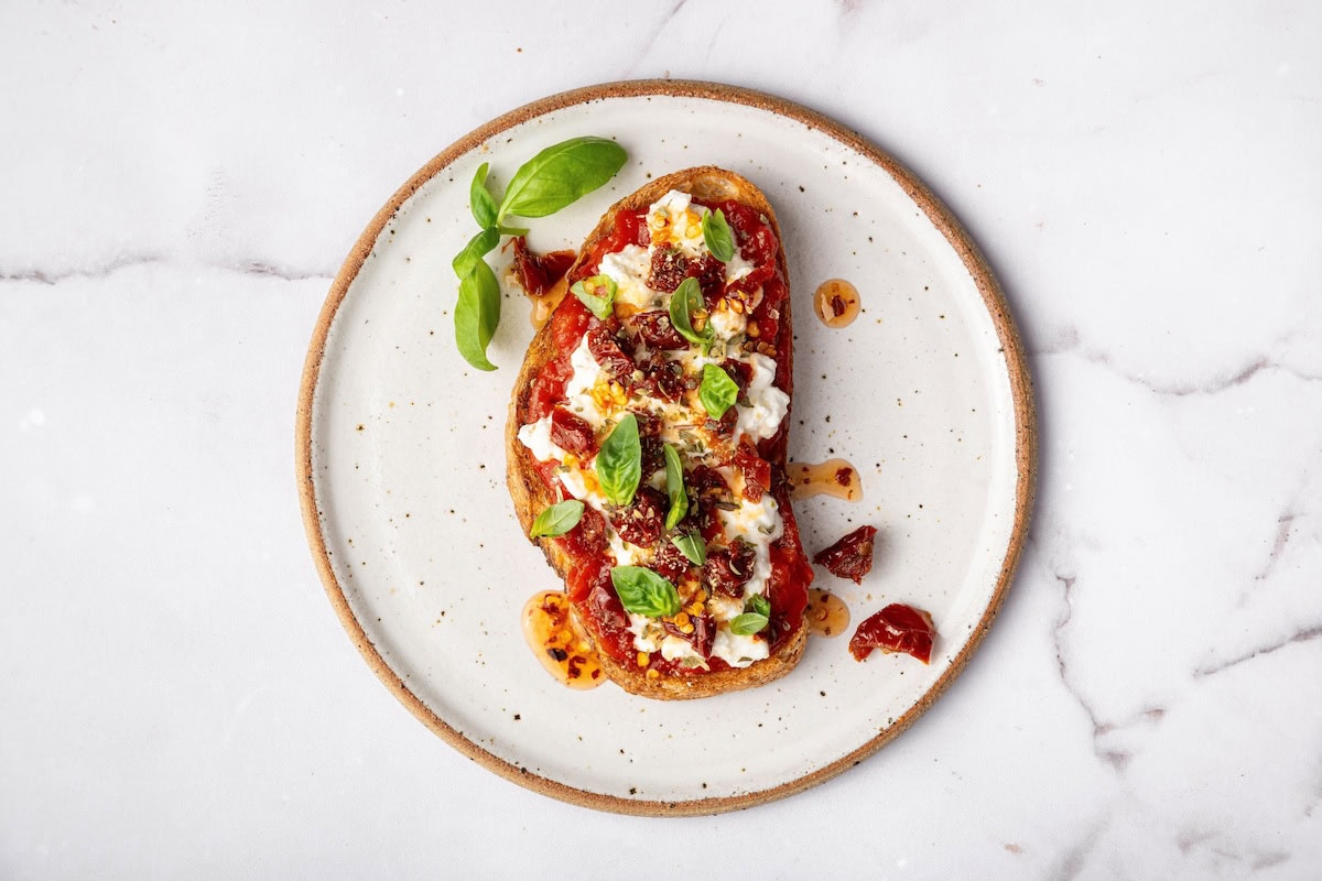 Cottage cheese toast with marinara, sun dried tomatoes, oregano, garlic powder, and fresh basil for a pizza-inspired variation.