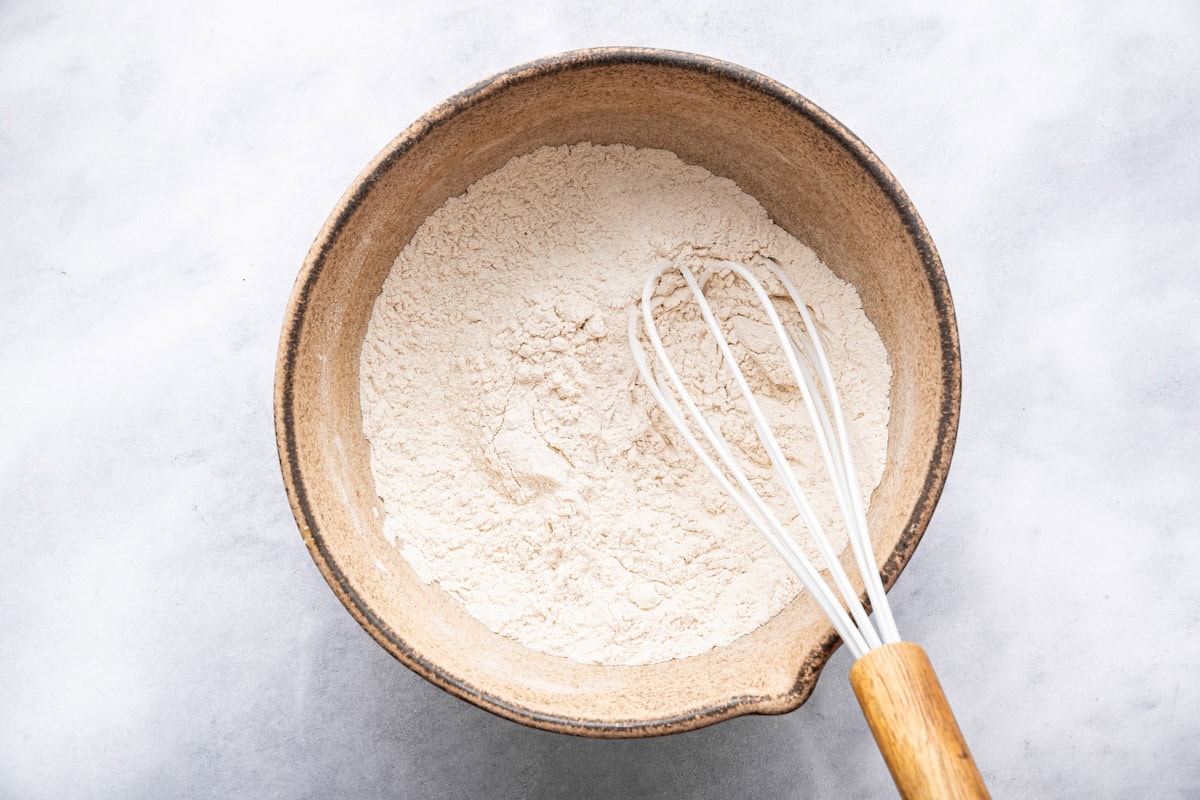 Bowl of dry ingredients with a whisk ready for making cottage cheese waffles.