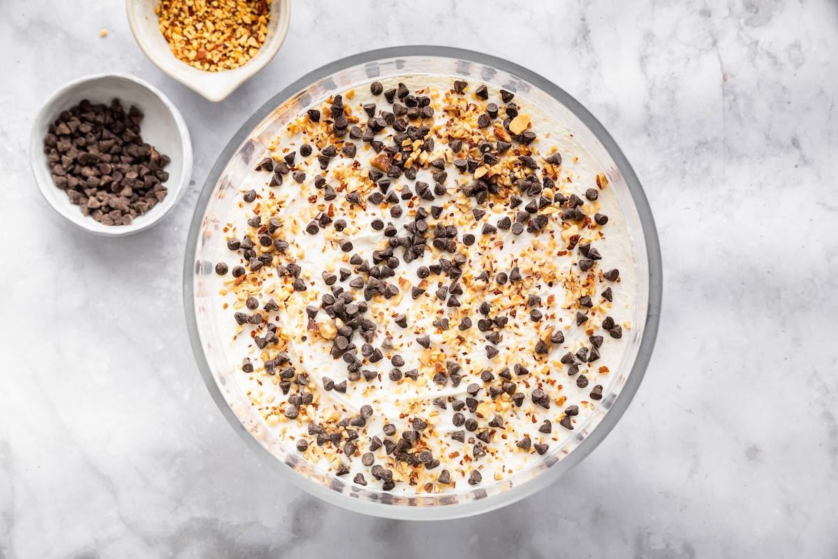 Overhead view of chocolate trifle topped with whipped cream, almonds and mini chocolate chips.