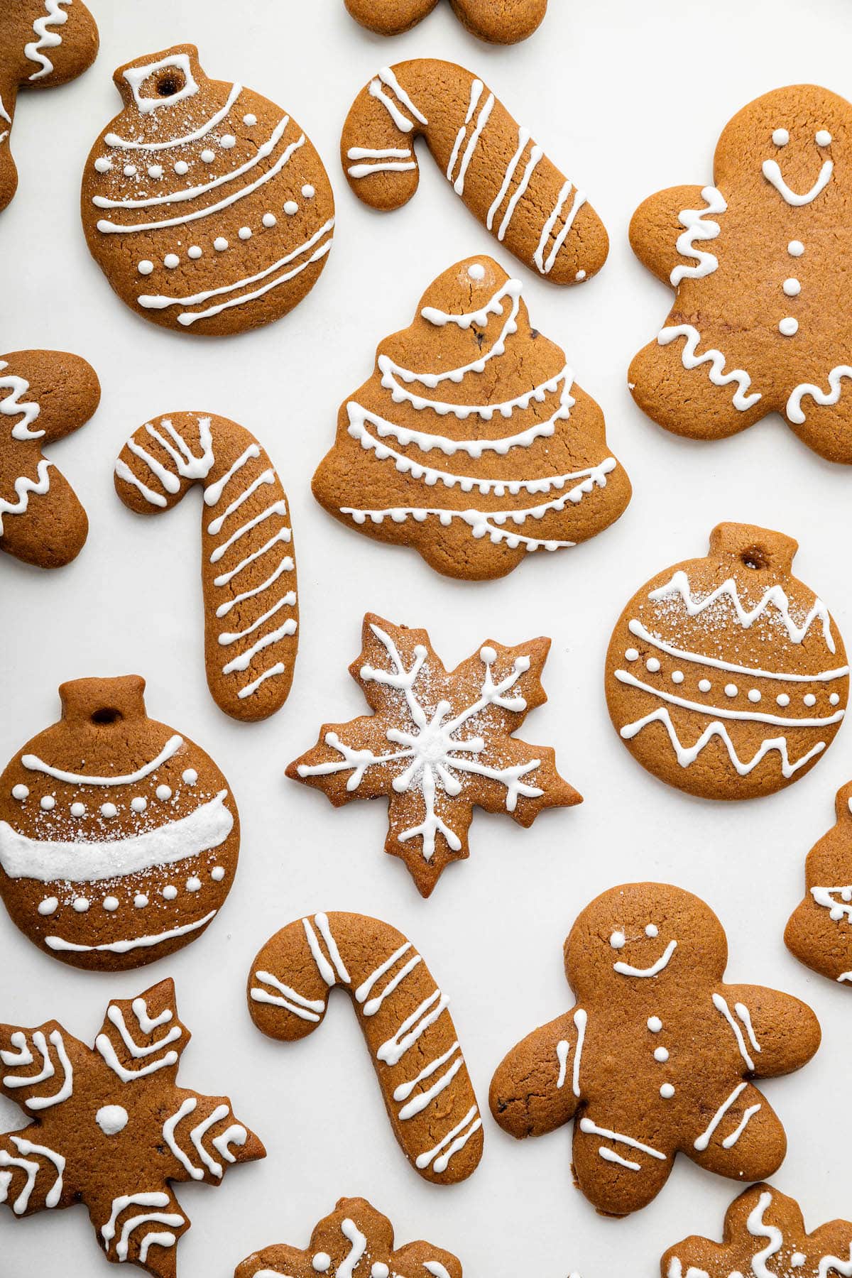 Multiple gingerbread cookies, designed with icing, near one another.