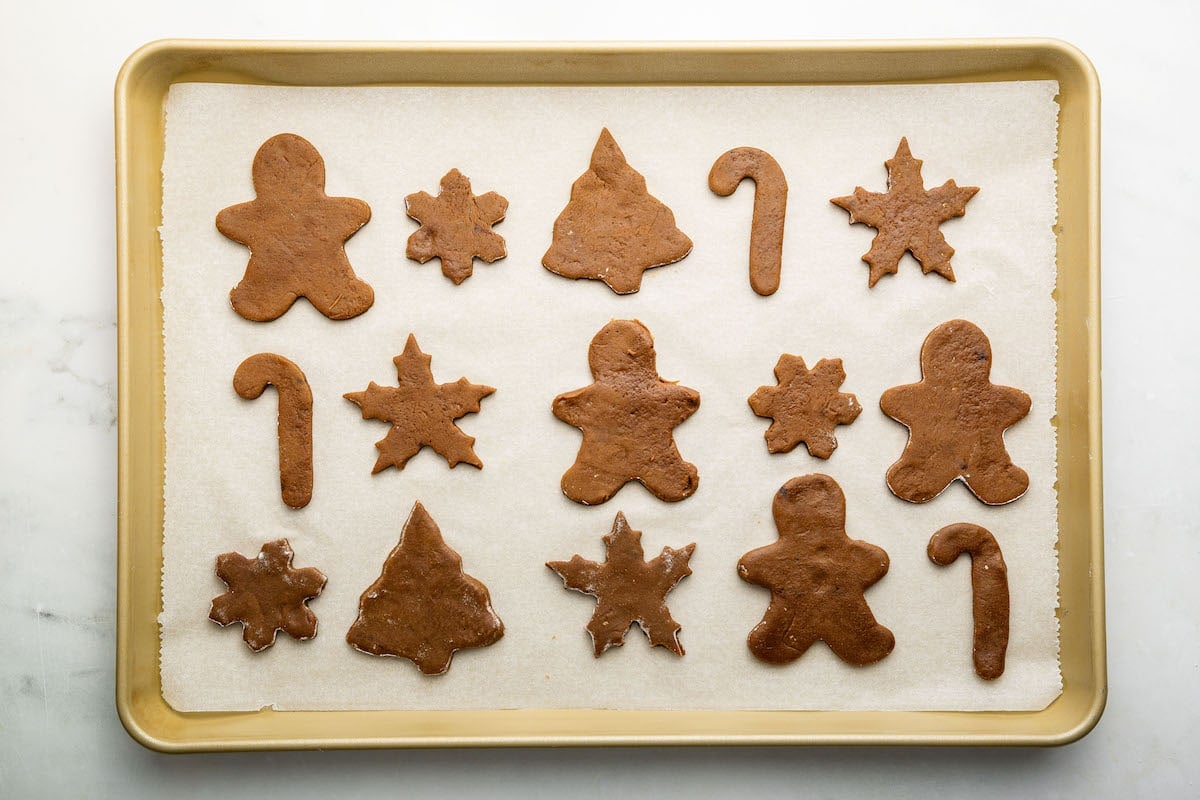 Gingerbread cookies on a baking tray before being baked in the oven.