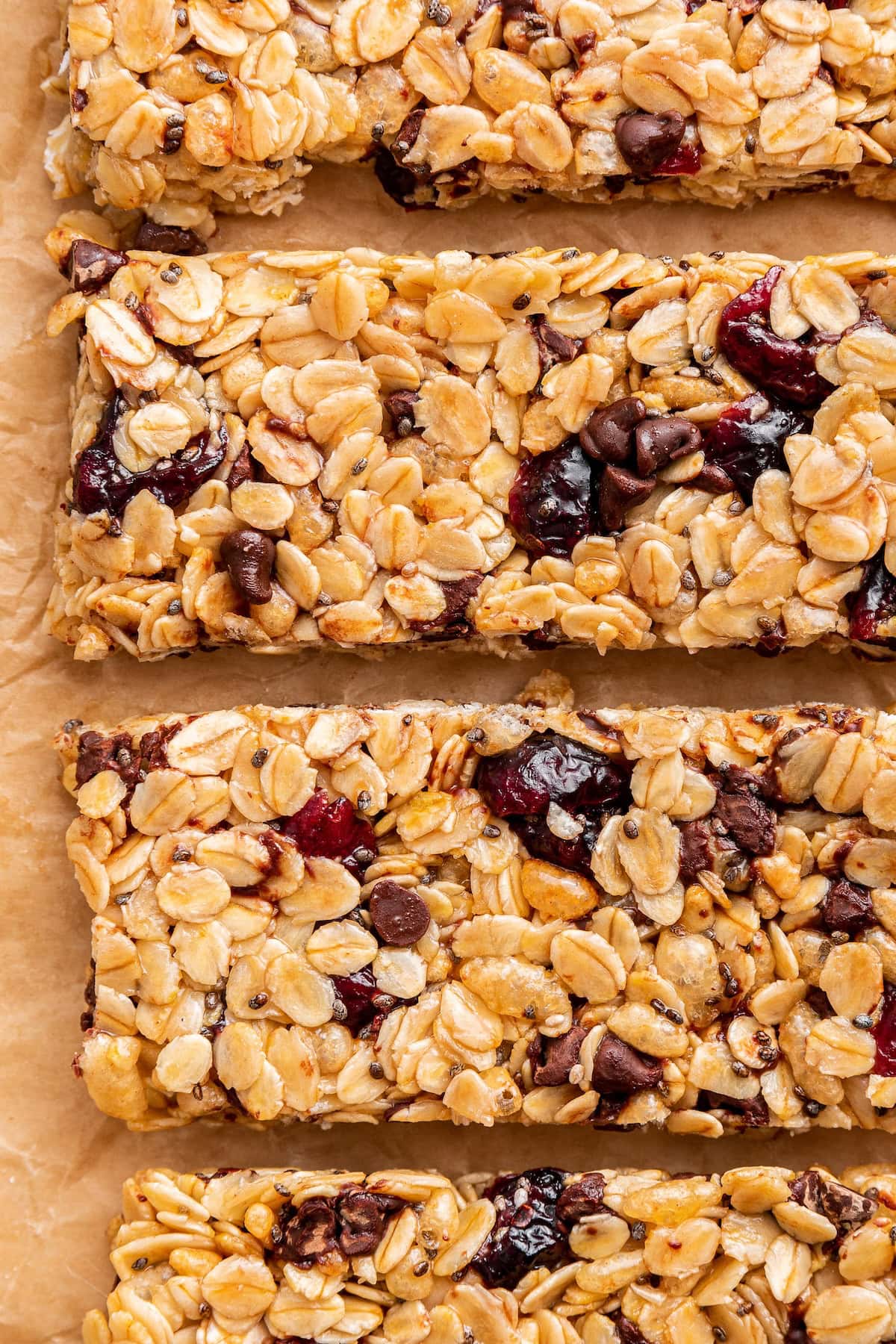 Four granola bars with chocolate chips and dried cranberries lined up near one another.