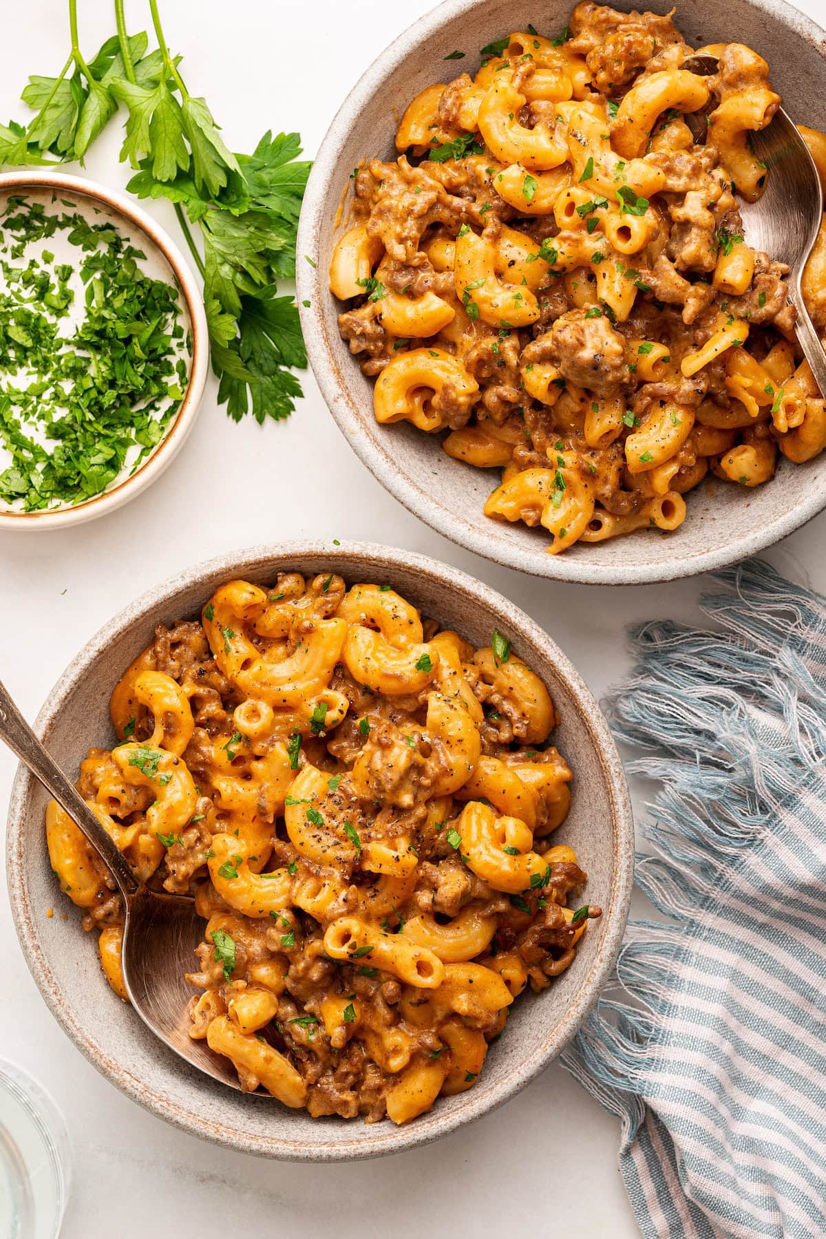 Servings of healthy hamburger helper with macaroni noodles and ground beef in two bowls.