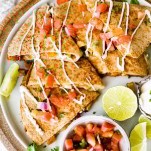 Healthy chicken quesadilla on a plate with a side bowl of pico de gallo.
