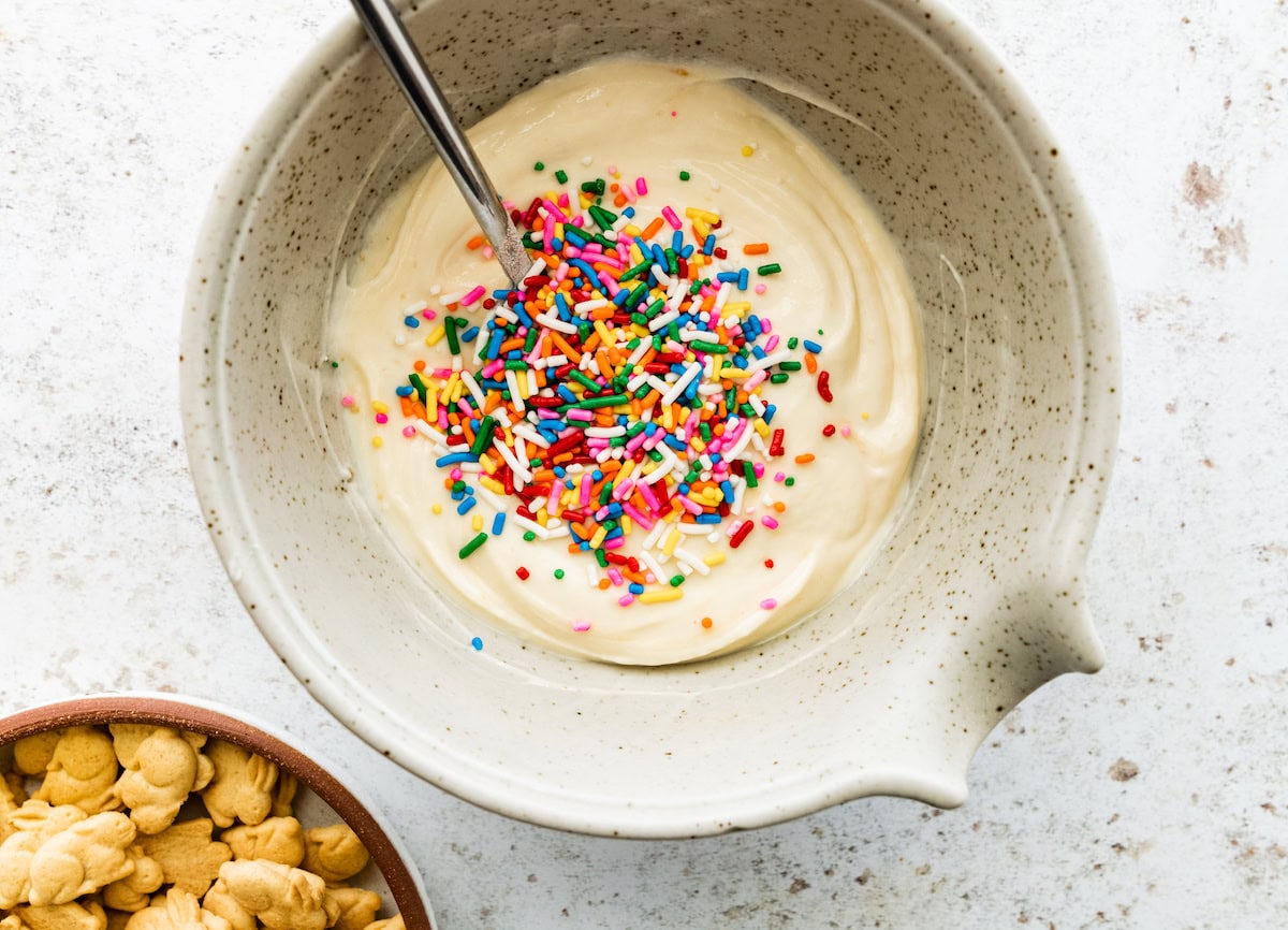 A large mixing bowl of Greek yogurt, protein powder, vanilla, and sprinkles.