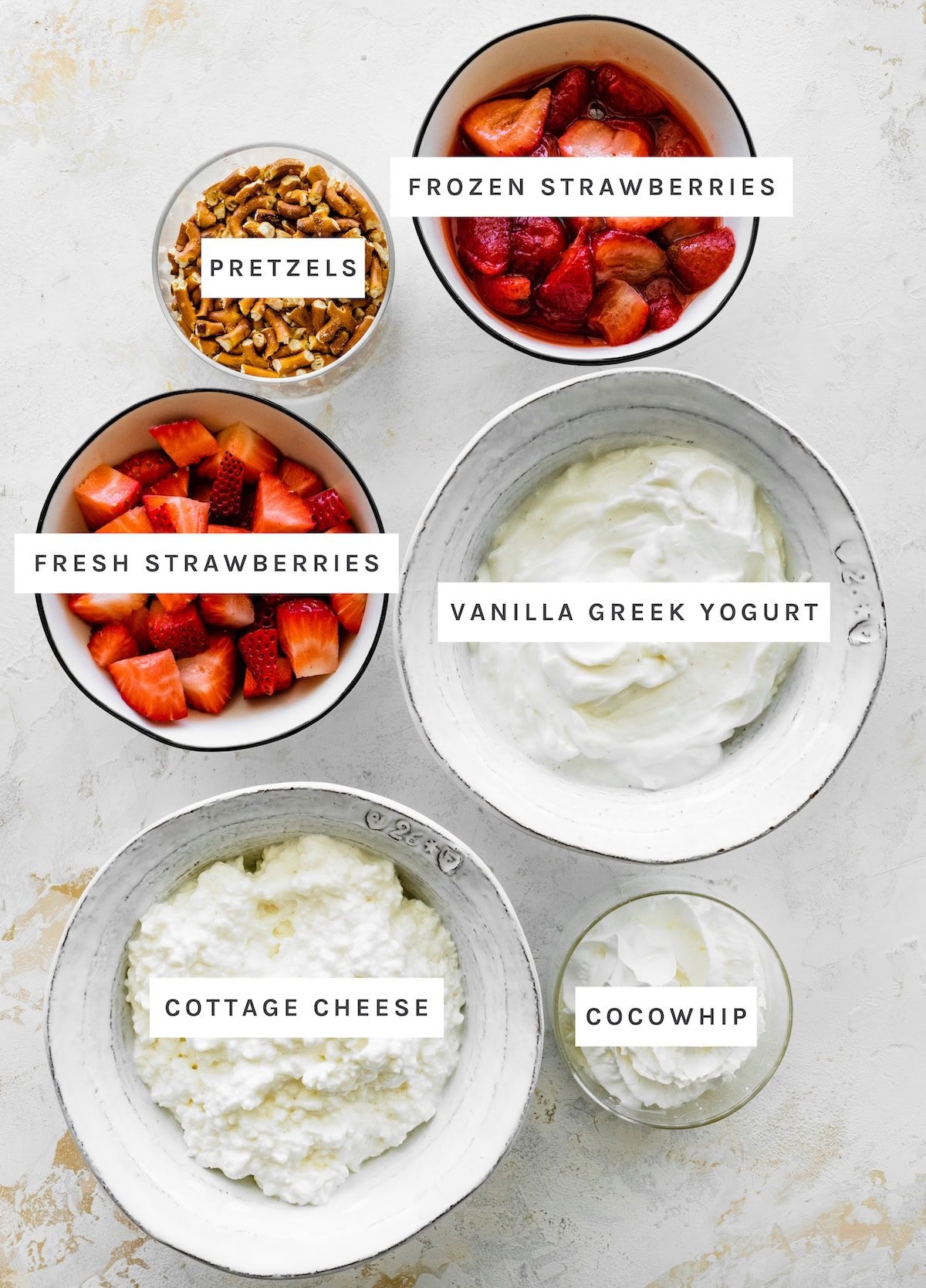 High Protein Strawberry Pretzel Salad Bowl ingredients: frozen strawberries, fresh strawberries, vanilla Greek yogurt, cottage cheese, CocoWhip.