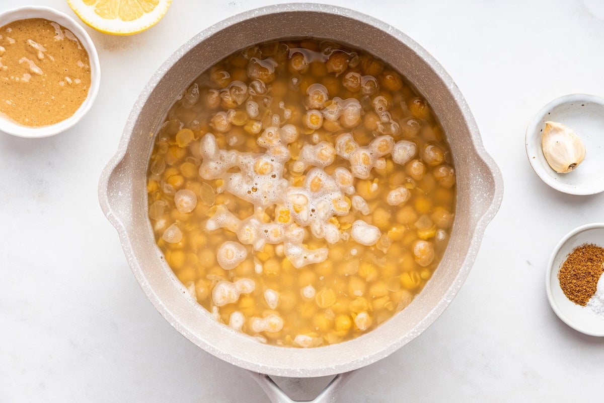A large pot of garbanzo beans cooking in water.