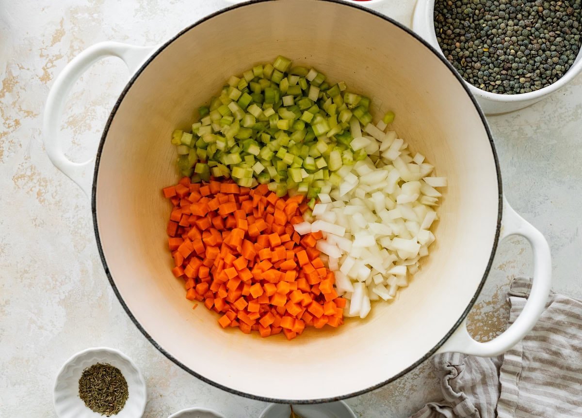 A large pot of diced onion, carrots, and celery before being sauteed.