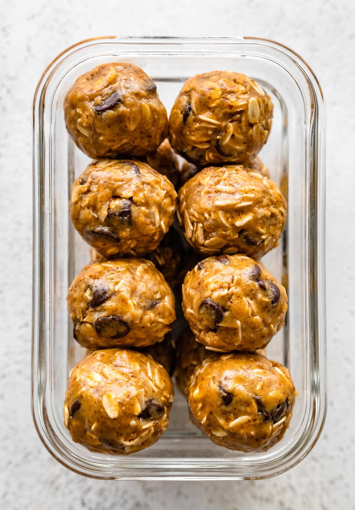 Square food storage container packed with peanut butter energy balls.