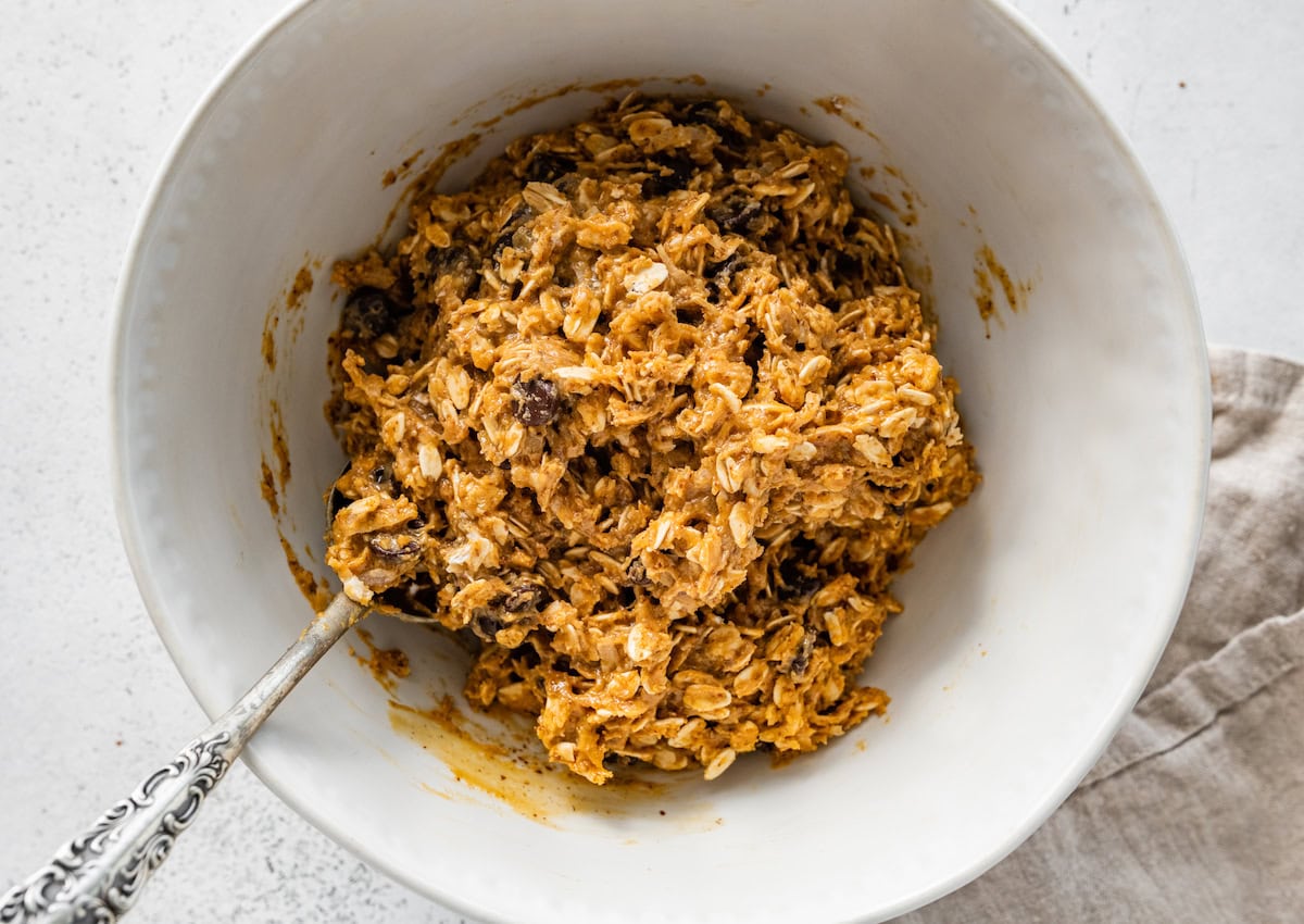 A large mixing bowl with all the ingredients for peanut butter energy balls combined into a sticky mixture.