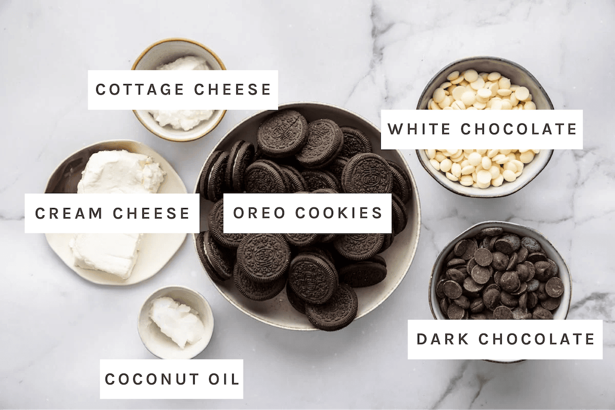 Ingredients for Oreo balls including Oreos, cream cheese, cottage cheese, coconut oil chocolate chips and white chocolate chips.