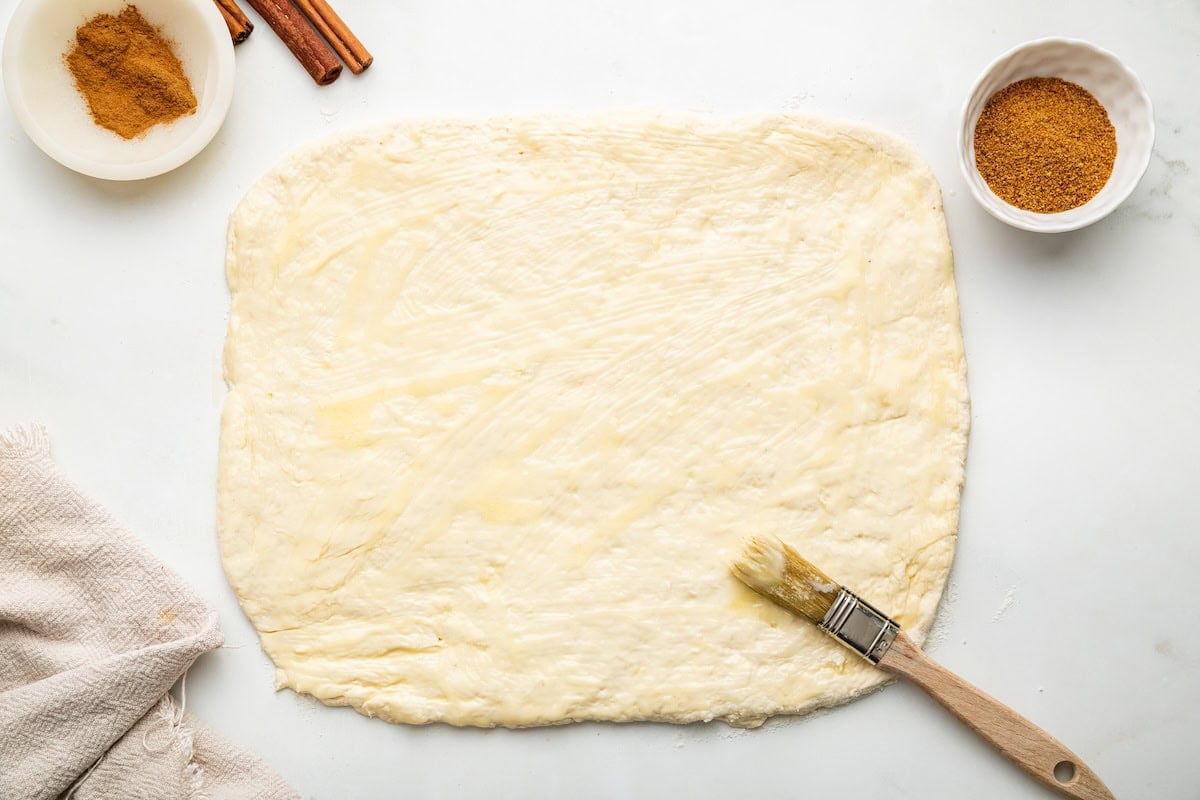 Butter spread over the flattened cinnamon roll dough.