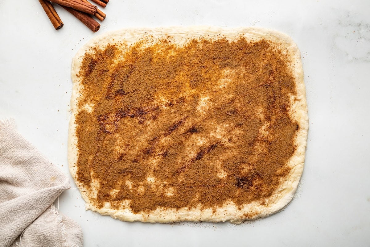 A cinnamon coconut sugar mixture spread across the cinnamon roll dough.