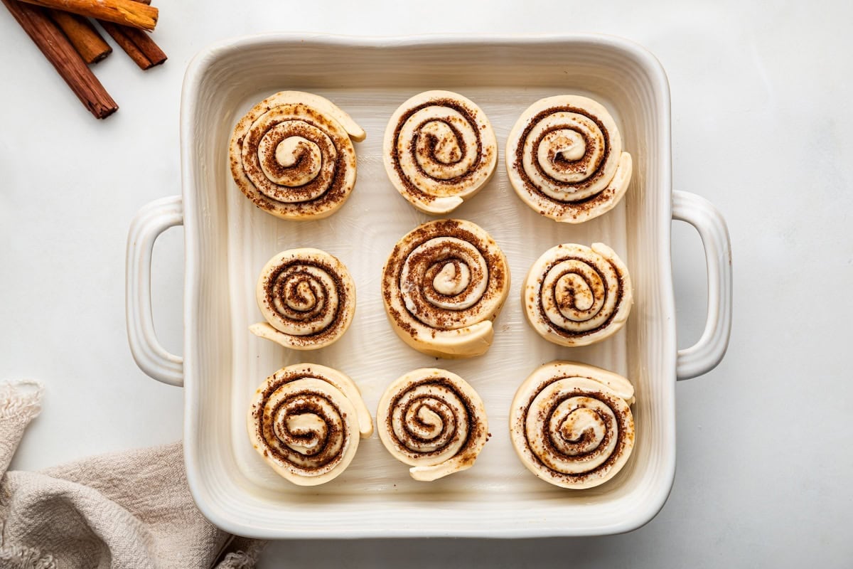 9 protein cinnamon rolls in a white square baking dish before being baked.