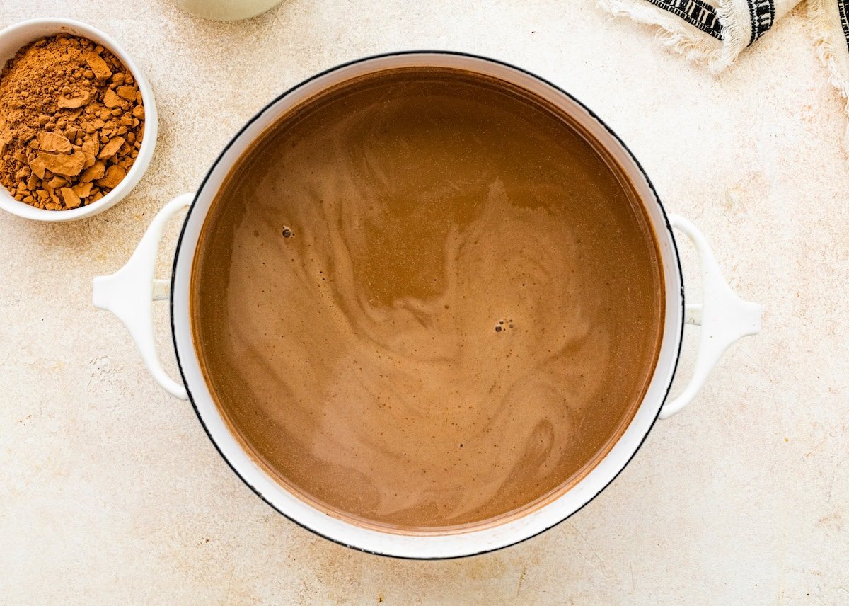 The protein hot chocolate mixture in a white skillet.