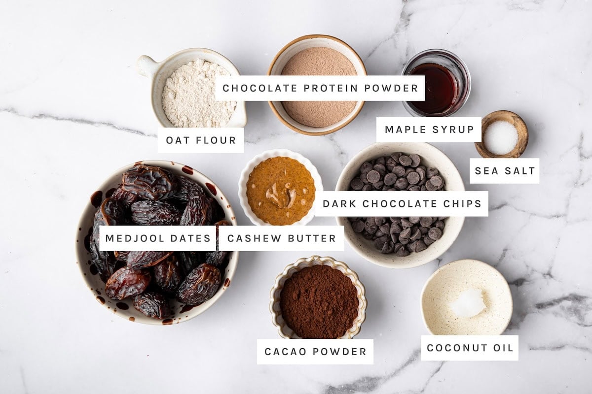 Salted Chocolate Protein Balls ingredients: Oat flour, chocolate protein powder, maple syrup, sea salt, dark chocolate chips, coconut oil, cacao powder, cashew butter, Medjool dates