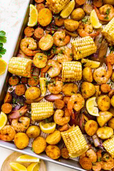 Sheet pan shrimp boil with golden potatoes, shrimp, sausage, and corn.