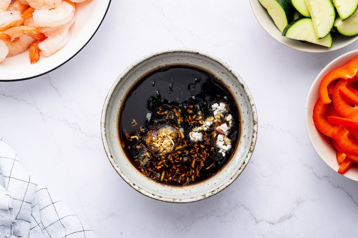 A bowl of stir-fry sauce with soy sauce, garlic, and cornstarch before being mixed.