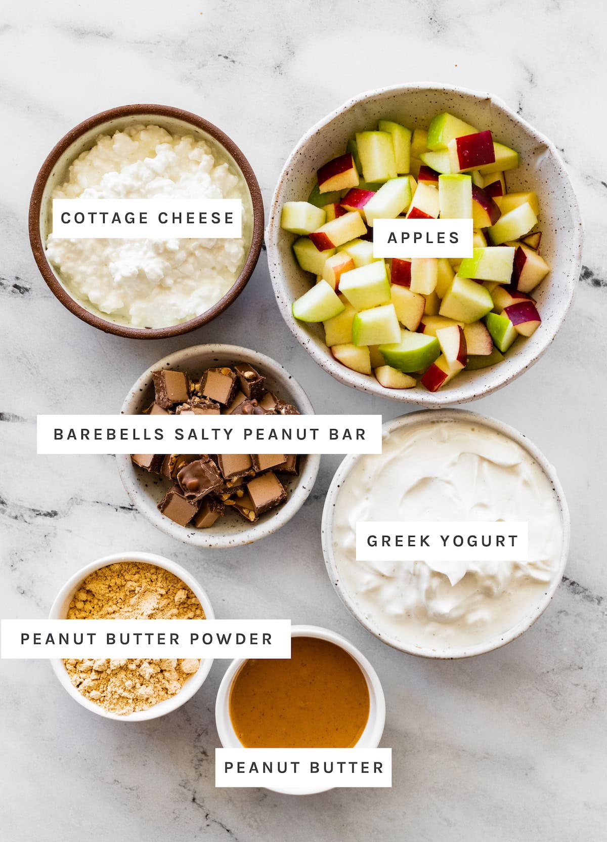 Snickers Salad Protein Bowl ingredients: Cottage cheese, apples, Barebells salty peanut bar, Greek yogurt, peanut butter powder, peanut butter.