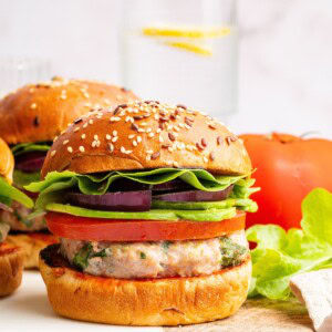 A spinach feta turkey burger served on a seeded bun with tomato, lettuce, red onion and avocado.