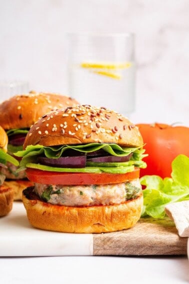 A spinach feta turkey burger served on a seeded bun with tomato, lettuce, red onion and avocado.