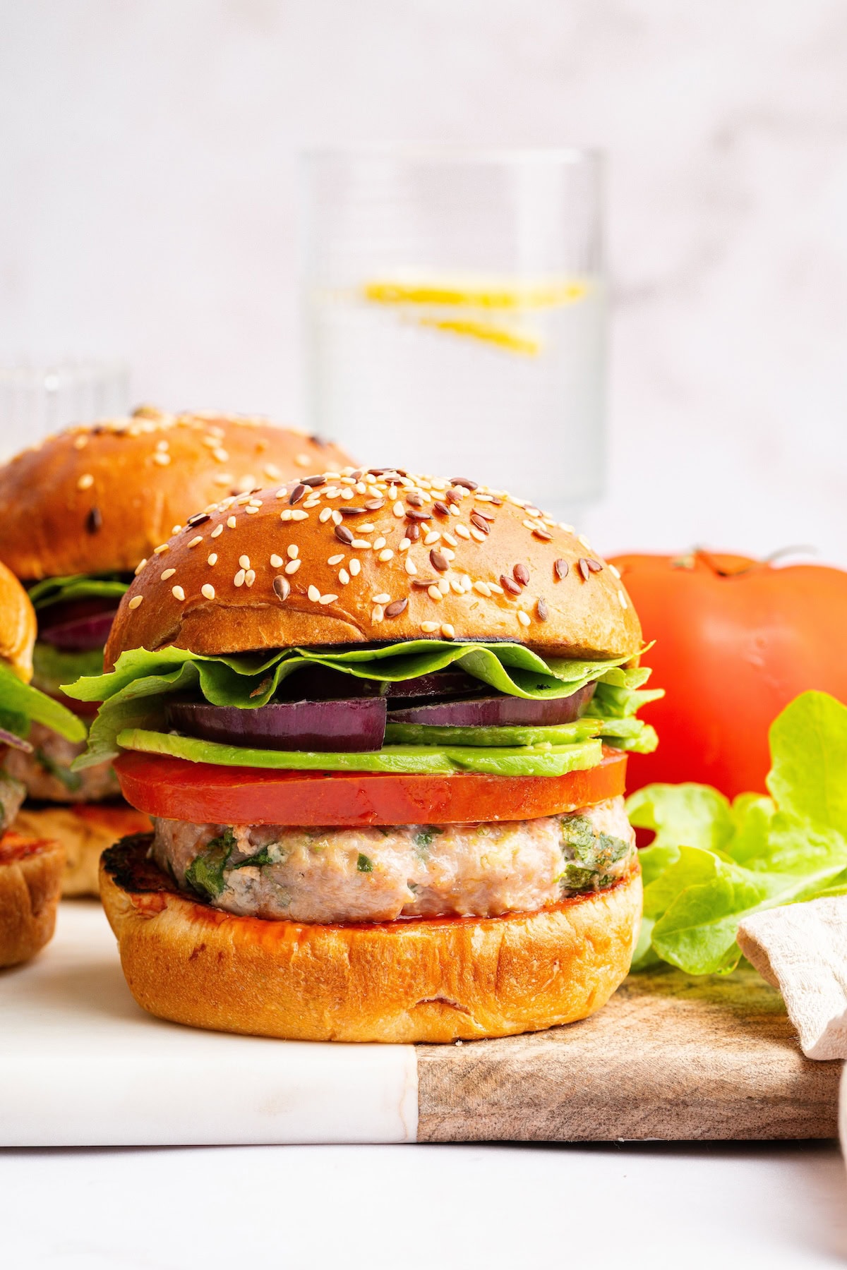 A spinach feta turkey burger served on a seeded bun with tomato, lettuce, red onion and avocado.