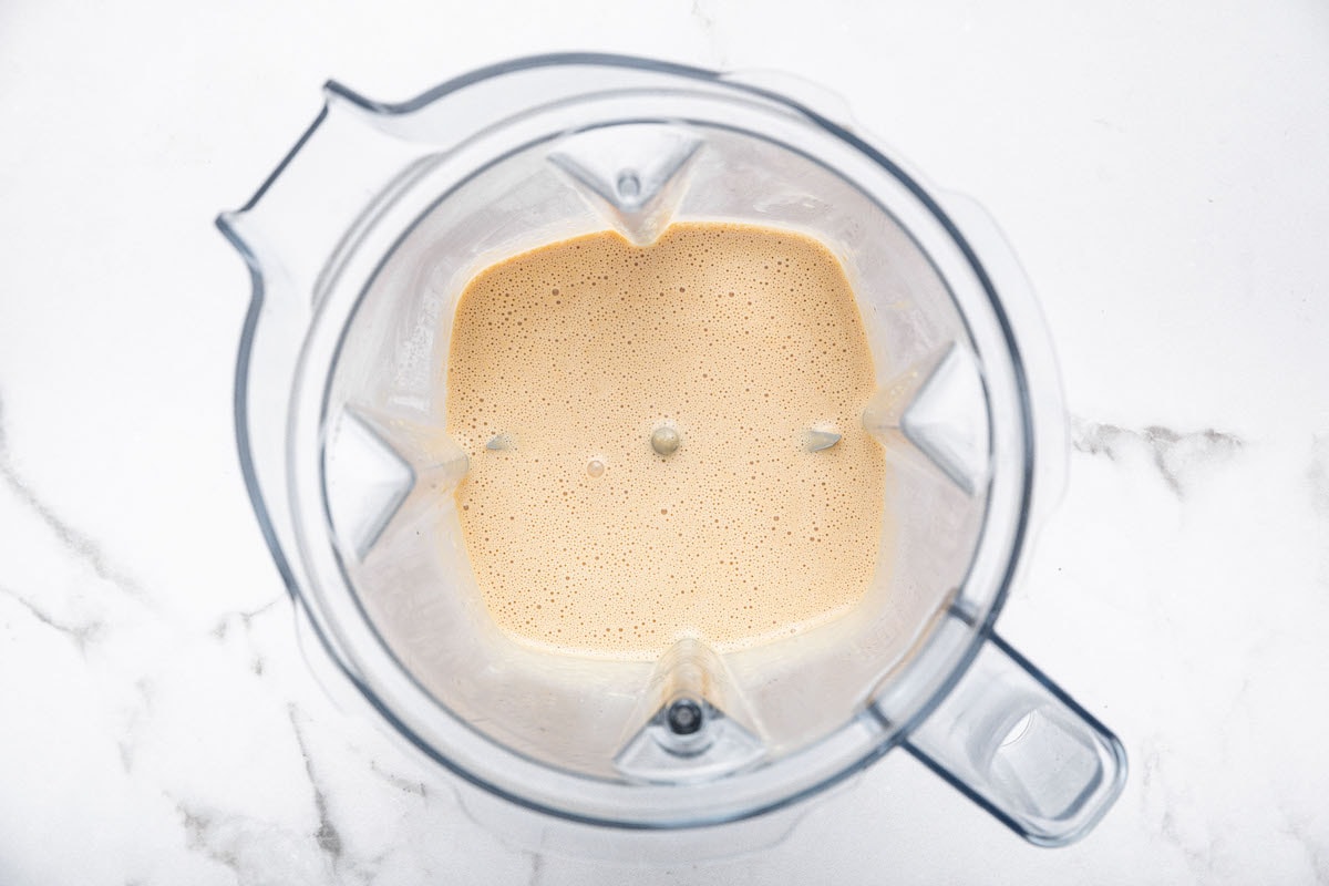 Creamy sesame ginger slaw dressing blended smooth in a high-speed blender.